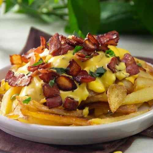 Batatas fritas com queijo cheddar fundido e bacon crocante