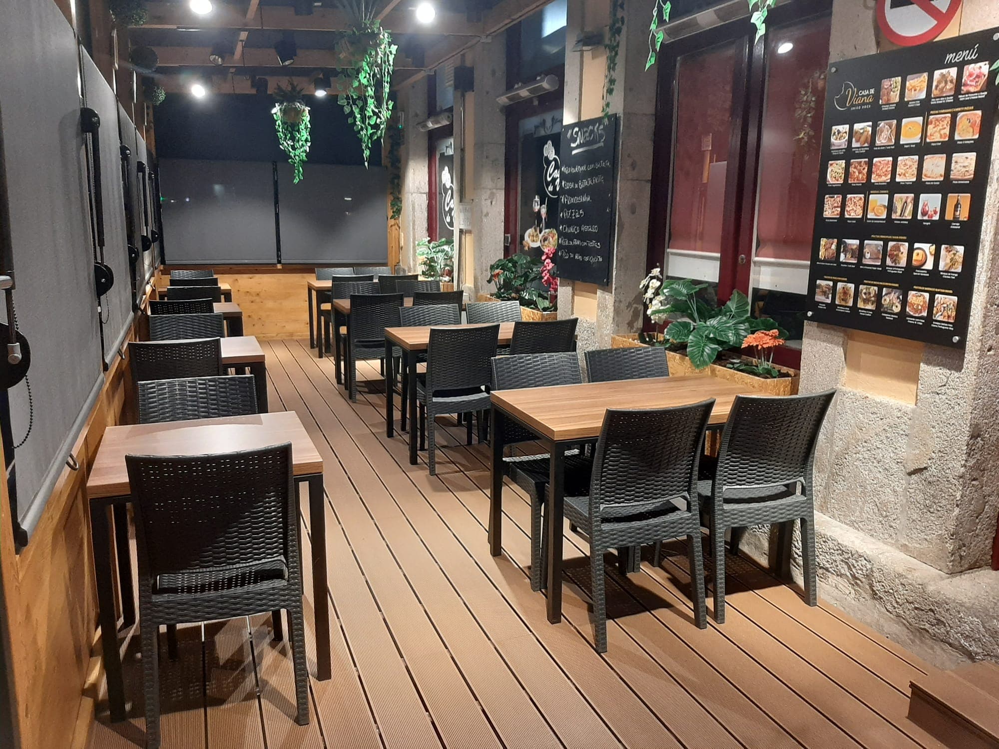 Ambiente noturno acolhedor e esplanada iluminada da Casa de Viana