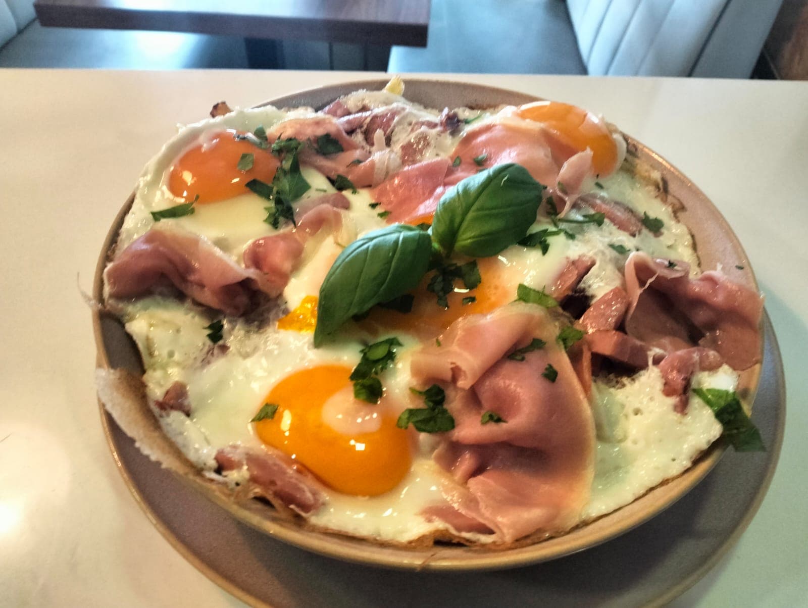 Ovos rotos com presunto fatiado e salsa fresca